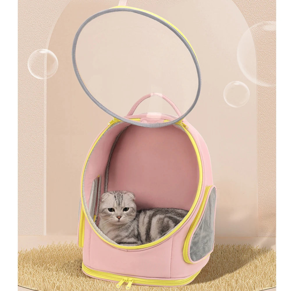 Sac à dos de transport pour chat rose pastel avec fenêtre bulle panoramique transparente ouverte, montrant un chat gris confortablement installé à l'intérieur sur un tapis douillet