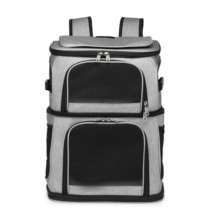 Sac à dos de transport gris pour deux chats avec double compartiment superposé, doté de larges fenêtres frontales en maille filet noire, de fermetures éclair robustes et de poches latérales de rangement.