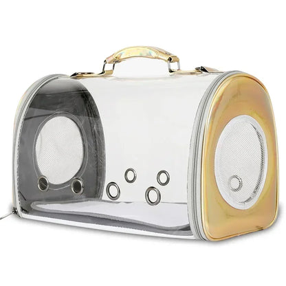 Sac de transport panoramique pour chat et petit chien en matériau transparent rigide avec finitions dorées irisées, équipé de six œillets de ventilation frontaux et d'une poignée de portage ergonomique.