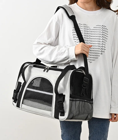 Sac de transport souple pour chat blanc et noir porté à l'épaule, doté de bandes réfléchissantes de sécurité, de fenêtres en maille respirante et d'une bandoulière rembourrée réglable.
