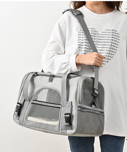 Sac de transport souple pour chat gris porté à l'épaule, doté d'une bandoulière rembourrée, de fenêtres en maille respirante et d'une bande réfléchissante de sécurité pour le voyage.