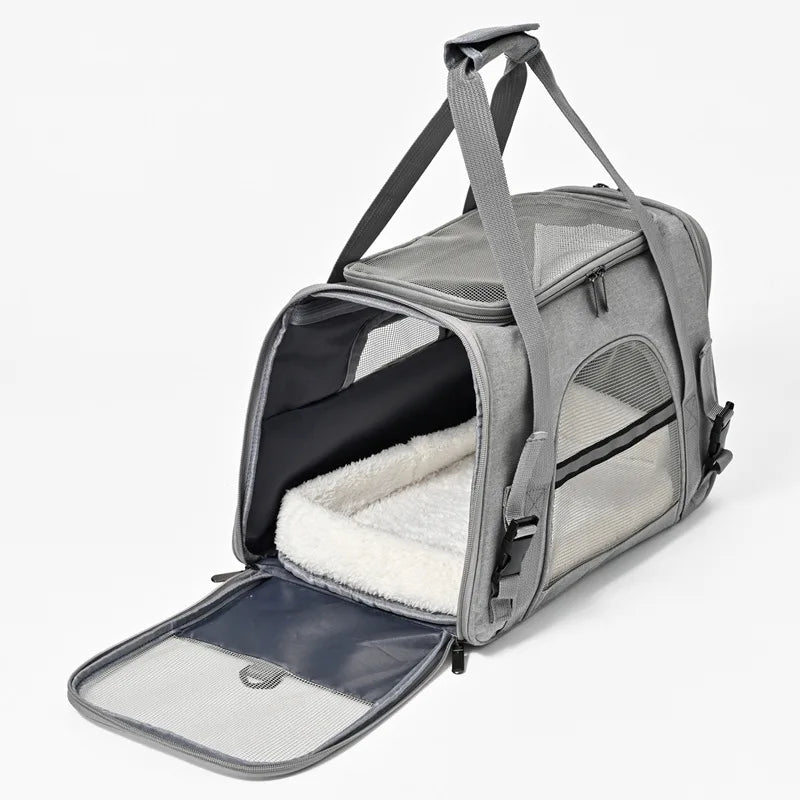 Vue ouverte d'un sac de transport pour chat gris clair révélant un grand tapis intérieur blanc moelleux, avec ouverture latérale zippée et fenêtres en maille respirante pour un confort maximal.