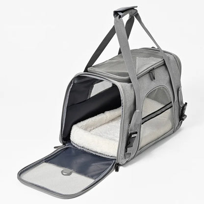 Vue ouverte d'un sac de transport pour chat gris clair révélant un grand tapis intérieur blanc moelleux, avec ouverture latérale zippée et fenêtres en maille respirante pour un confort maximal.