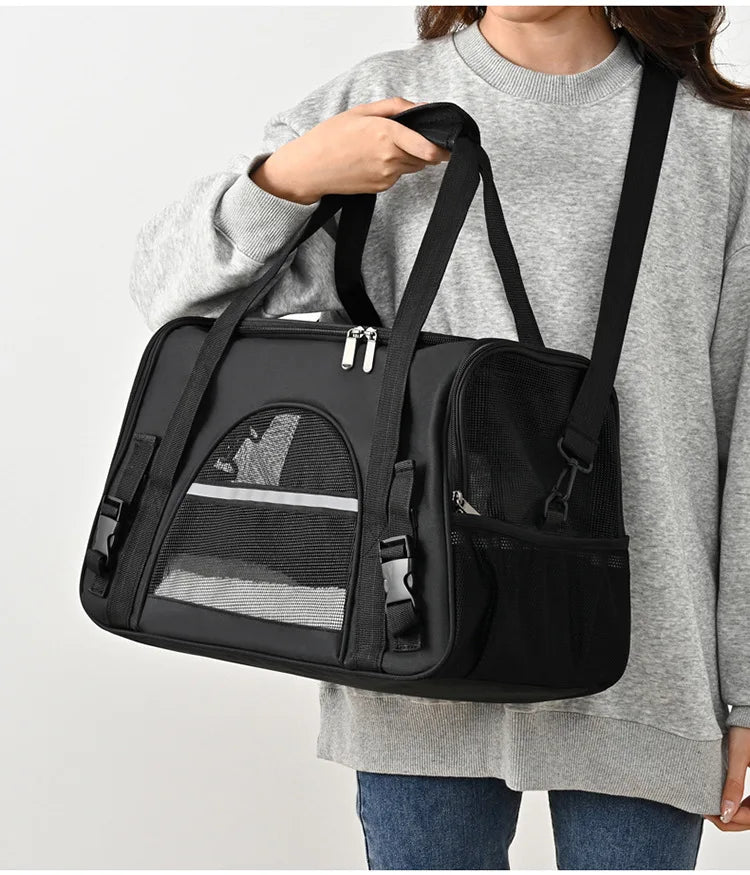 Sac de transport souple pour chat noir porté à l'épaule, doté de bandes réfléchissantes de sécurité, de fenêtres en maille respirante et d'une bandoulière rembourrée réglable.