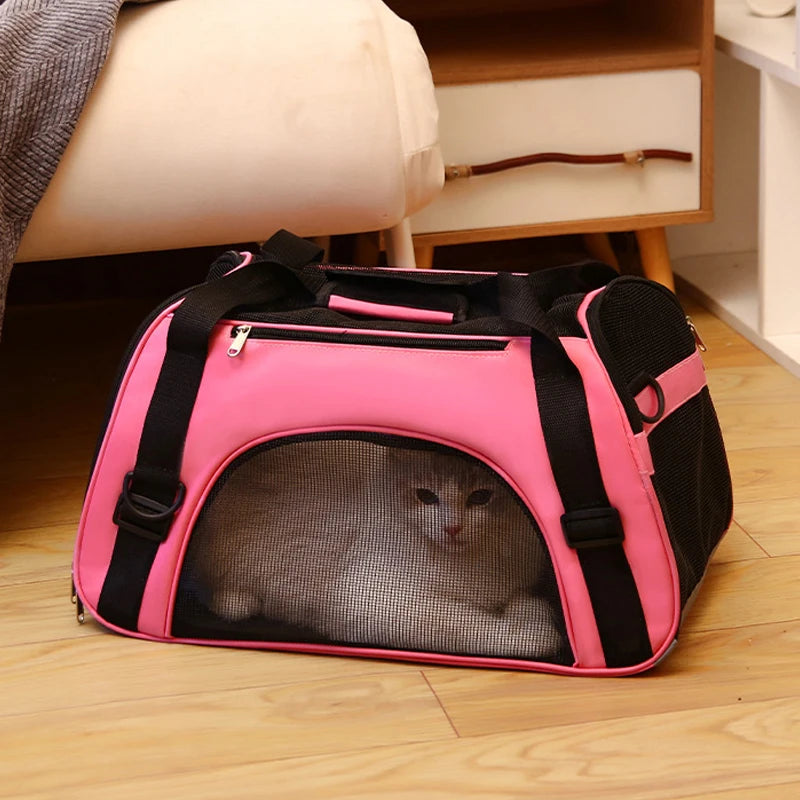 Sac de transport souple pour chat en tissu rose vif avec larges fenêtres en maille respirante noire, doté d'une poignée rembourrée et d'une bandoulière, montré avec un chat gris à l'intérieur.