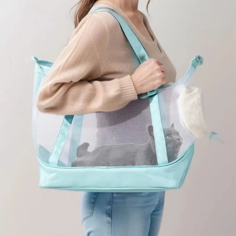 Femme portant à l'épaule un sac de transport transparent pour chat bleu turquoise avec vue panoramique, montrant un chat gris confortablement installé et profitant d'une visibilité totale.