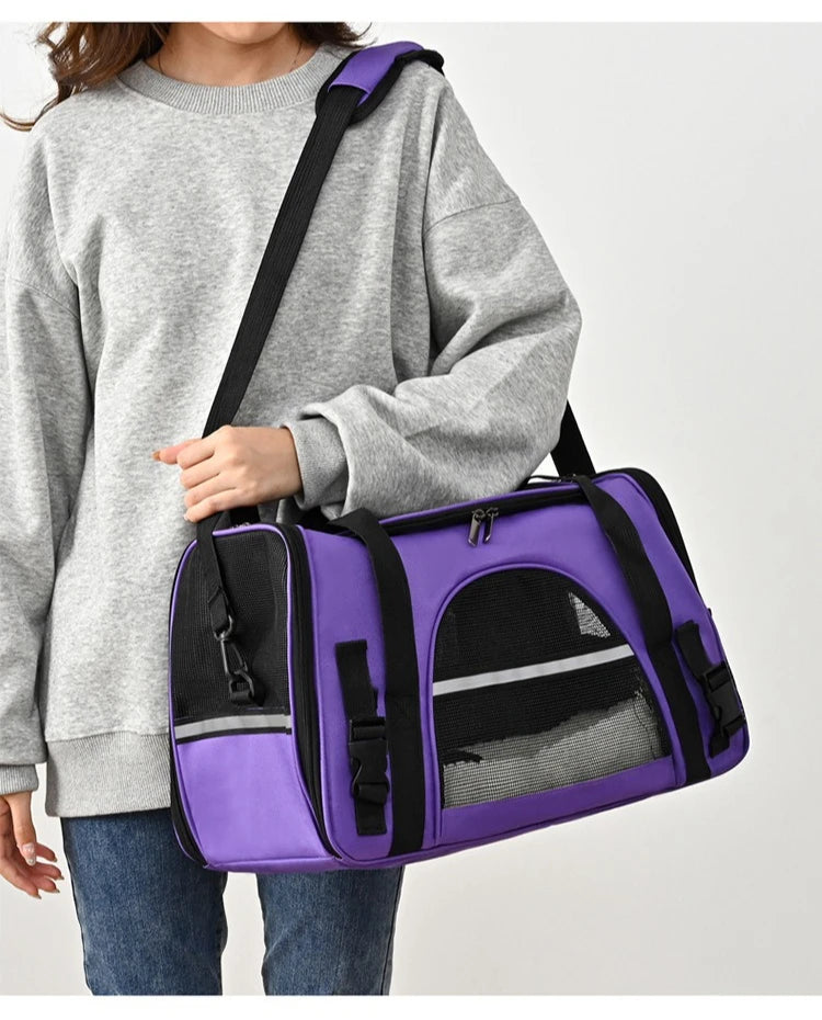 Sac de transport souple pour chat violet porté à l'épaule, doté de bandes réfléchissantes de sécurité, de fenêtres en maille respirante noire et d'une bandoulière rembourrée réglable.