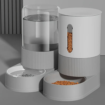 Duo élégant de distributeur croquettes chat et abreuvoir automatique gris au design minimaliste. Le visuel montre le réservoir d'eau transparent et le réservoir de nourriture avec fenêtre de contrôle verticale. Ce distributeur croquettes par gravité assure une alimentation constante sans électricité. Parfait comme distributeur croquettes chien miniature pour un intérieur moderne et épuré.
