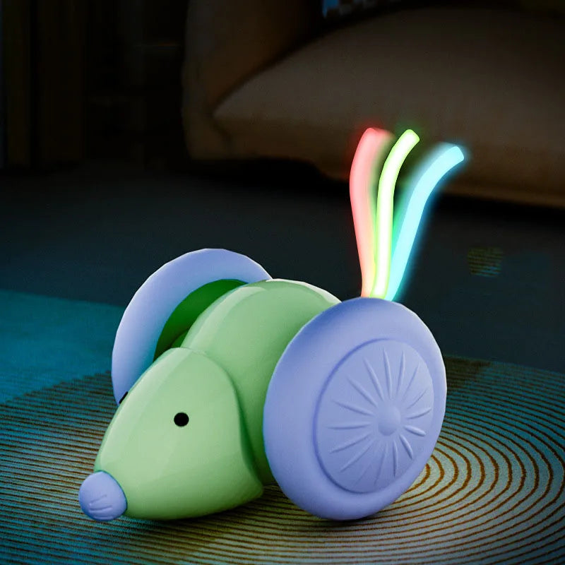 Photographie en gros plan du robot souris interactif de la marque Les Trésors d'Owka, mettant en avant ses effets lumineux LED multicolores. Ce jouet chat innovant, de couleur vert menthe avec de larges roues violettes, est présenté sur un tapis, illustrant sa capacité de déplacement sur différentes textures. L'image souligne la fonction d'éveil nocturne grâce à des faisceaux lumineux rouge, vert et bleu qui stimulent l'instinct de chasse du félin même dans l'obscurité. Ce dispositif de jeux pour chat techn