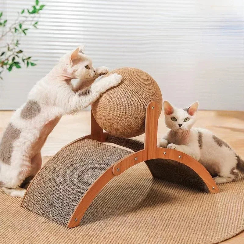 Deux chats blancs et gris jouant avec une station de griffage comprenant une grande balle rotative en sisal et une base arquée en bois avec surface en carton ondulé servant de tunnel.