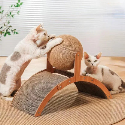 Deux chats blancs et gris jouant avec une station de griffage comprenant une grande balle rotative en sisal et une base arquée en bois avec surface en carton ondulé servant de tunnel.