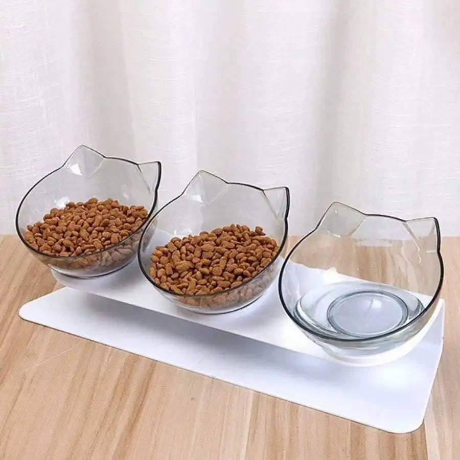 Station de repas triple avec gamelle pour chat transparente en forme d'oreilles de chat. Le support blanc surélevé et incliné à 15° assure une position ergonomique qui protège les cervicales. Cette gamelle chat triple permet de séparer l'eau et les croquettes. Un ensemble gamelle chaton design et anti-vomi idéal pour une digestion saine et un intérieur élégant.
