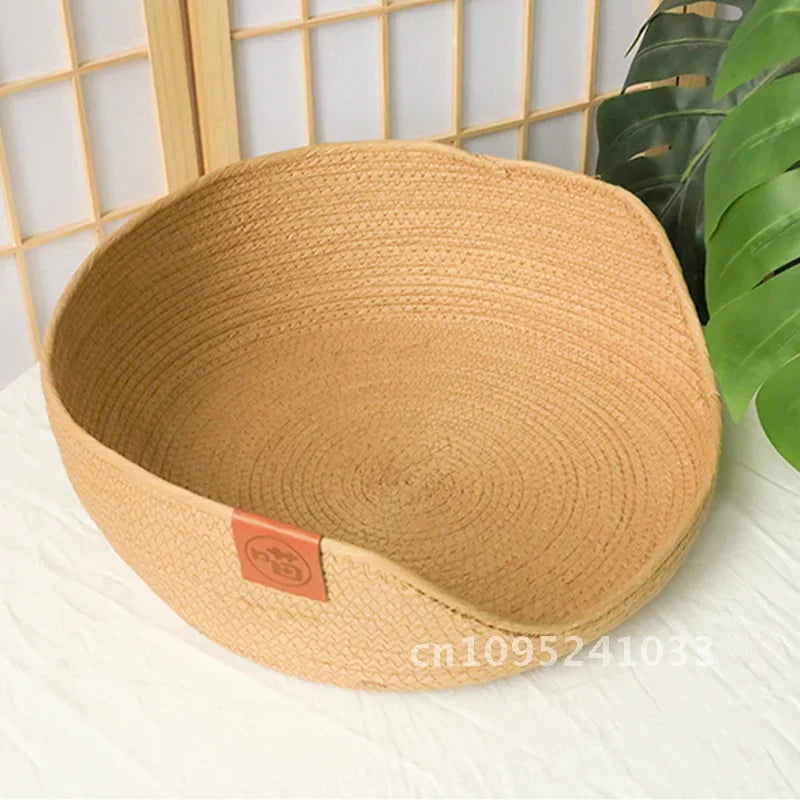 Vue intérieure d'un panier pour chat en corde tressée beige de haute qualité, montrant la structure circulaire robuste, le bord avant abaissé et un écusson décoratif en cuir marron.