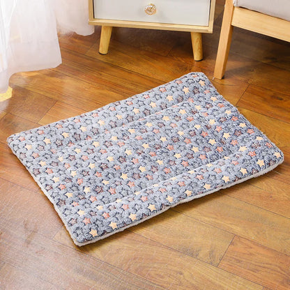 Tapis chat rectangulaire gris avec motifs étoiles, posé sur un parquet en bois clair dans un intérieur élégant. Ce coussin à chat matelassé offre une surface en peluche épaisse et moelleuse. Coussin pour chat au design scandinave, chaud et ultra-doux, idéal pour le repos quotidien. Qualité Les Trésors d'Owka.