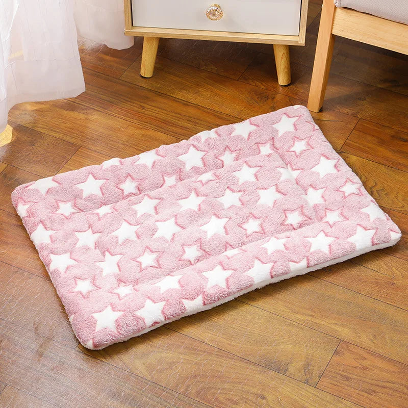 Tapis chat rectangulaire rose avec motifs étoiles blanches, posé sur un parquet chaleureux. Ce coussin à chat matelassé en peluche épaisse offre un confort thermique et une douceur extrême. Coussin pour chat au design élégant et moderne, idéal pour un repos cocooning. Qualité prestige Les Trésors d'Owka.
