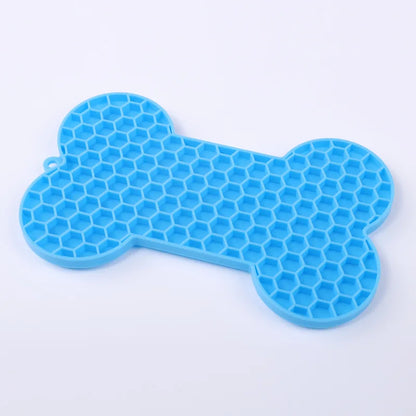 Tapis de léchage en silicone alimentaire bleu en forme d'os avec texture nid d'abeille pour chien et chat. Ce tapis à lécher anti-stress et anti-glouton favorise l'apaisement par le léchage et offre une occupation mentale saine. Un tapis léchage robuste et facile à nettoyer pour réduire l'anxiété de votre animal au quotidien.