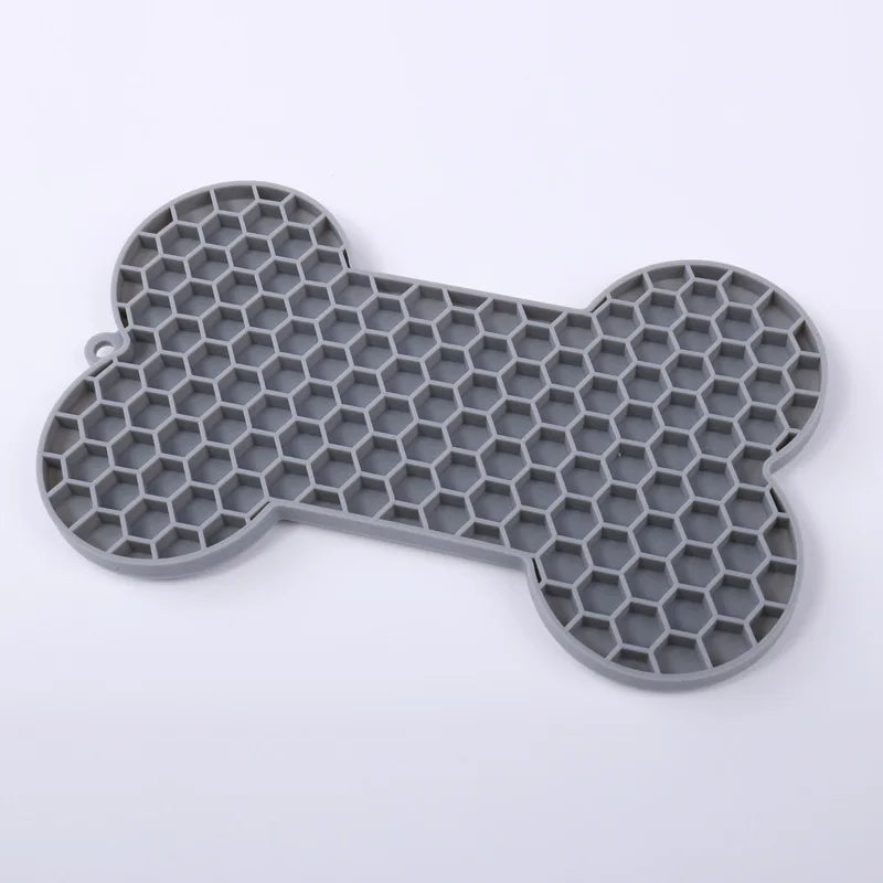 Tapis de léchage en silicone alimentaire gris en forme d'os avec texture nid d'abeille pour chien et chat. Ce tapis à lécher anti-stress et anti-glouton favorise l'apaisement par le léchage et offre une occupation mentale saine. Un tapis léchage robuste et facile à nettoyer pour réduire l'anxiété de votre animal au quotidien.