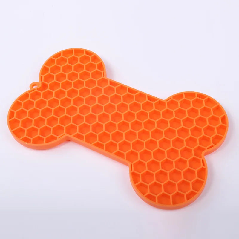 Tapis de léchage en silicone alimentaire orange en forme d'os avec texture nid d'abeille pour chien et chat. Ce tapis à lécher anti-stress et anti-glouton favorise l'apaisement par le léchage et offre une occupation mentale saine. Un tapis léchage robuste et facile à nettoyer pour réduire l'anxiété de votre animal.