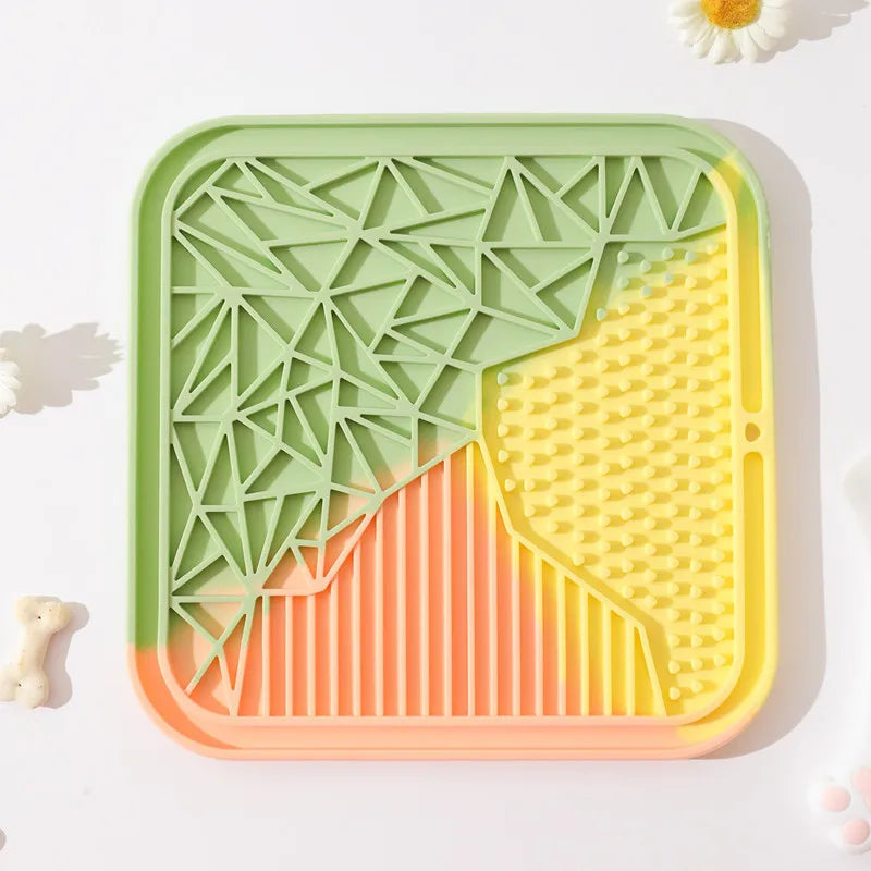 Tapis de léchage carré tricolore vert, jaune et orange en silicone alimentaire pour chien et chat avec 4 textures variées pour l'enrichissement. Ce tapis à lécher anti-stress et anti-glouton favorise l'apaisement et l'hygiène bucco-dentaire de votre animal. Un tapis léchage durable et coloré idéal pour une occupation mentale saine.