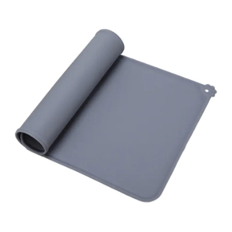 Tapis de gamelle gris en silicone souple partiellement enroulé, imperméable et antidérapant pour chien et chat, avec rebord anti-débordement et motif patte d'animal.