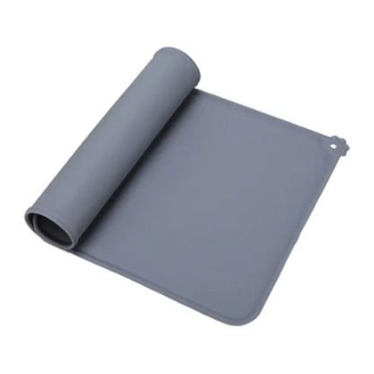 Tapis de gamelle gris en silicone souple partiellement enroulé, imperméable et antidérapant pour chien et chat, avec rebord anti-débordement et motif patte d'animal.
