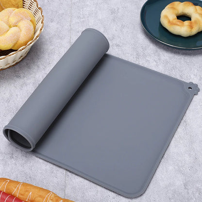Tapis de gamelle gris en silicone souple partiellement enroulé, imperméable et antidérapant pour chien et chat, avec rebord anti-débordement et motif patte d'animal.