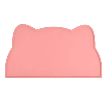 Photographie de face sur fond blanc du tapis gamelles chat en silicone rose poudré de la marque Les Trésors d'Owka. Ce tapis chat arbore un design élégant en forme de tête de félin avec des rebords surélevés anti-débordement pour contenir les projections d'eau et de nourriture. Fabriqué en silicone alimentaire de haute qualité, ce tapis gamelles est totalement imperméable, antidérapant et conçu pour protéger vos sols avec style. Sa finition mate et son coloris pastel en font l'accessoire d'hygiène idéal pou