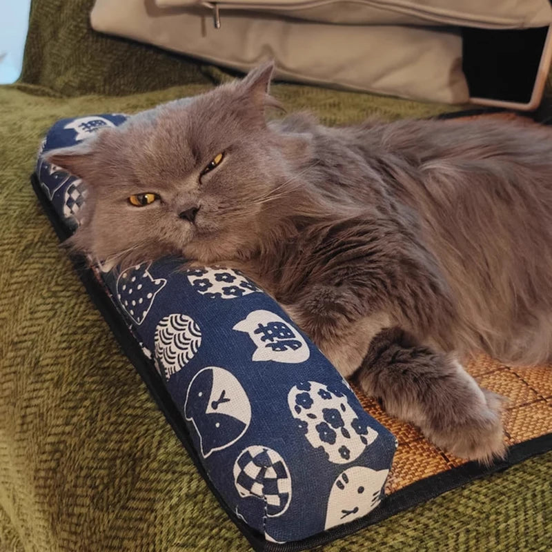 Gros plan d'un chat gris à poils longs se reposant sur un tapis rafraichissant chat en rotin tressé. L'image montre l'utilisation de l'oreiller ergonomique bleu. Ce coussin rafraichissant chat en fibres naturelles régule la température sans gel. Coussin froid pour chat idéal pour les fortes chaleurs. Qualité Les Trésors d'Owka.