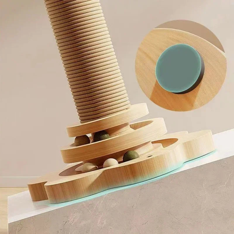 Gros plan sur la base d'une tour de jeu pour chat en bois montrant le circuit de balles interactif et un zoom sur les patins antidérapants fixés sous le socle pour une stabilité maximale.