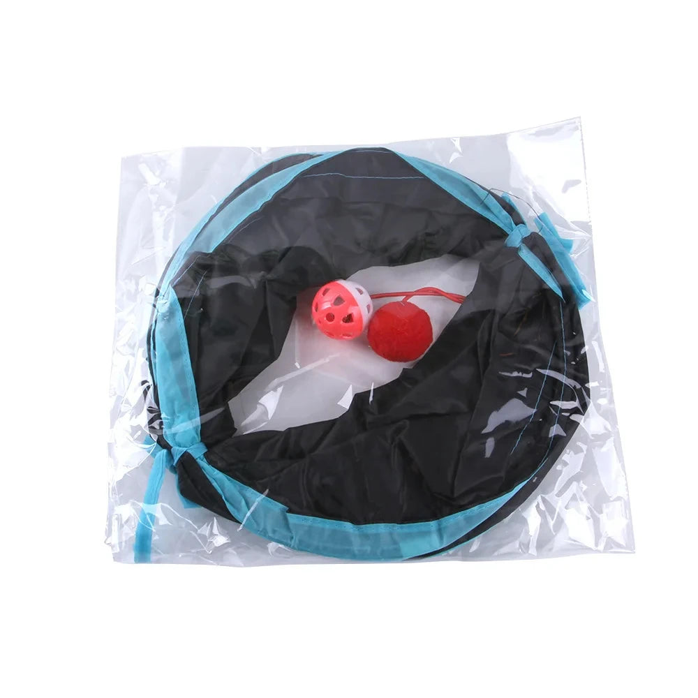 Tunnel de jeu pliable pour chat en nylon noir et bleu, présenté dans son emballage transparent, incluant une balle grelot et un pompon rouge suspendus pour l'éveil du chaton.