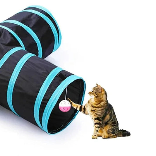 Chat tigré qui tend la patte vers la boule à grelot suspendue à l'entrée d'un tunnel pour chat en T — Les Trésors d'Owka
