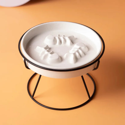 Plan rapproché montrant une gamelle anti-glouton pour chat en céramique blanche surélevée sur son support en métal noir. Le zoom met en évidence le labyrinthe intérieur en relief (arêtes de poisson), conçu comme un anti glouton chat efficace pour ralentir la prise de nourriture et améliorer la digestion. Solution santé et design disponible chez Les Trésors d'Owka.