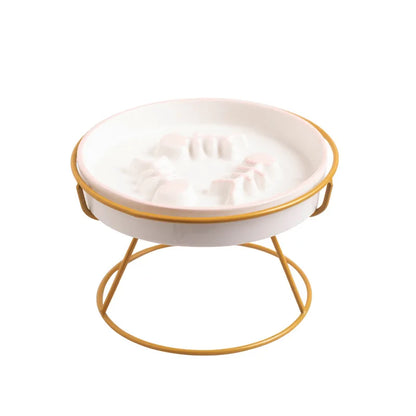 Plan rapproché montrant l'action de verser de l'eau sur une gamelle anti-glouton pour chat en céramique blanche. Le zoom met en évidence le labyrinthe intérieur en relief (arêtes de poisson), conçu comme un anti glouton chat efficace pour ralentir la prise de nourriture et améliorer la digestion. Illustration de la facilité d'entretien du design hygiénique, disponible chez Les Trésors d'Owka.